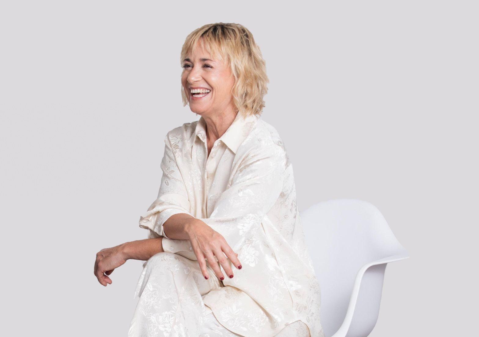 Olga Marset sentada, riendo